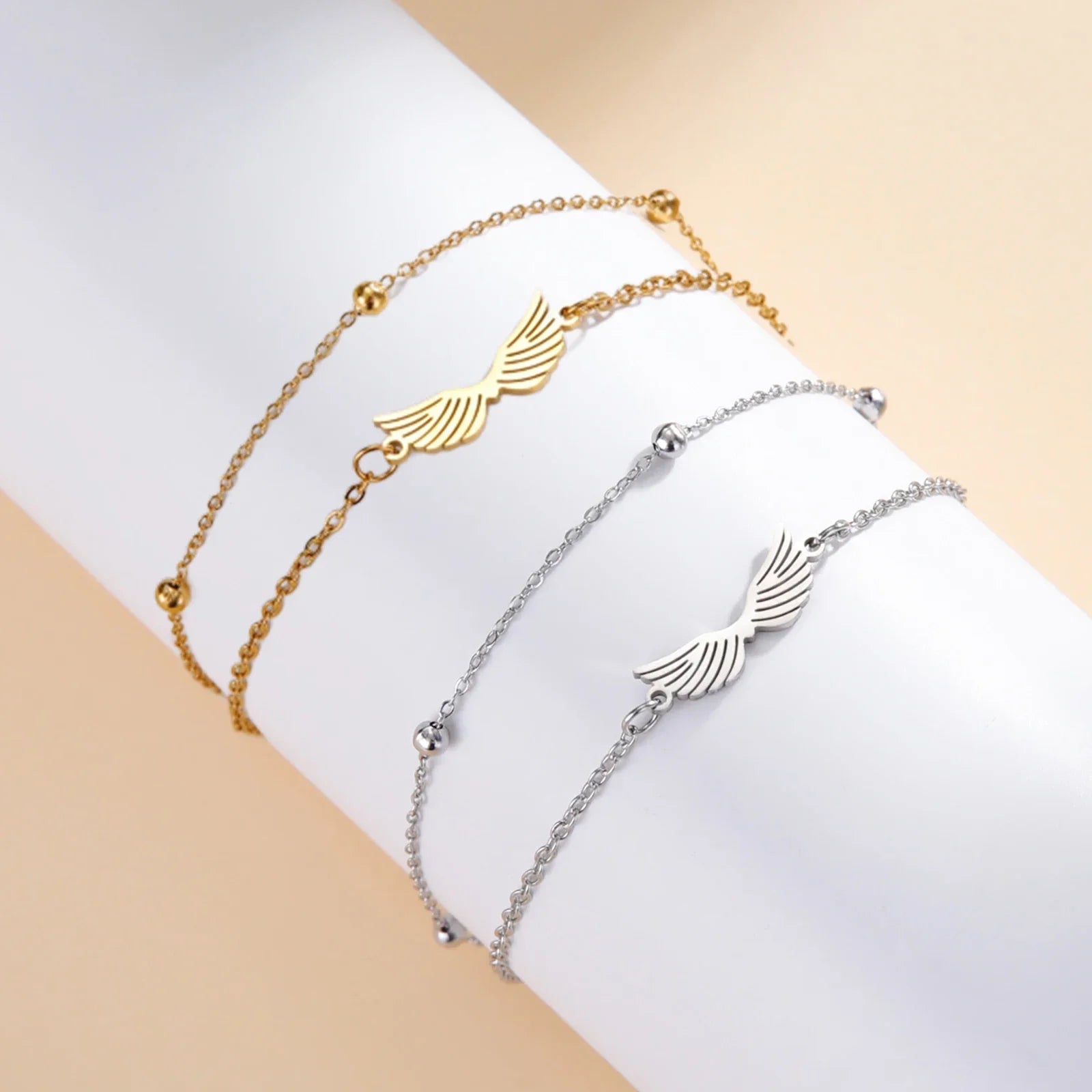 Bracelet aile d'ange doré à double chaîne porté au poignet