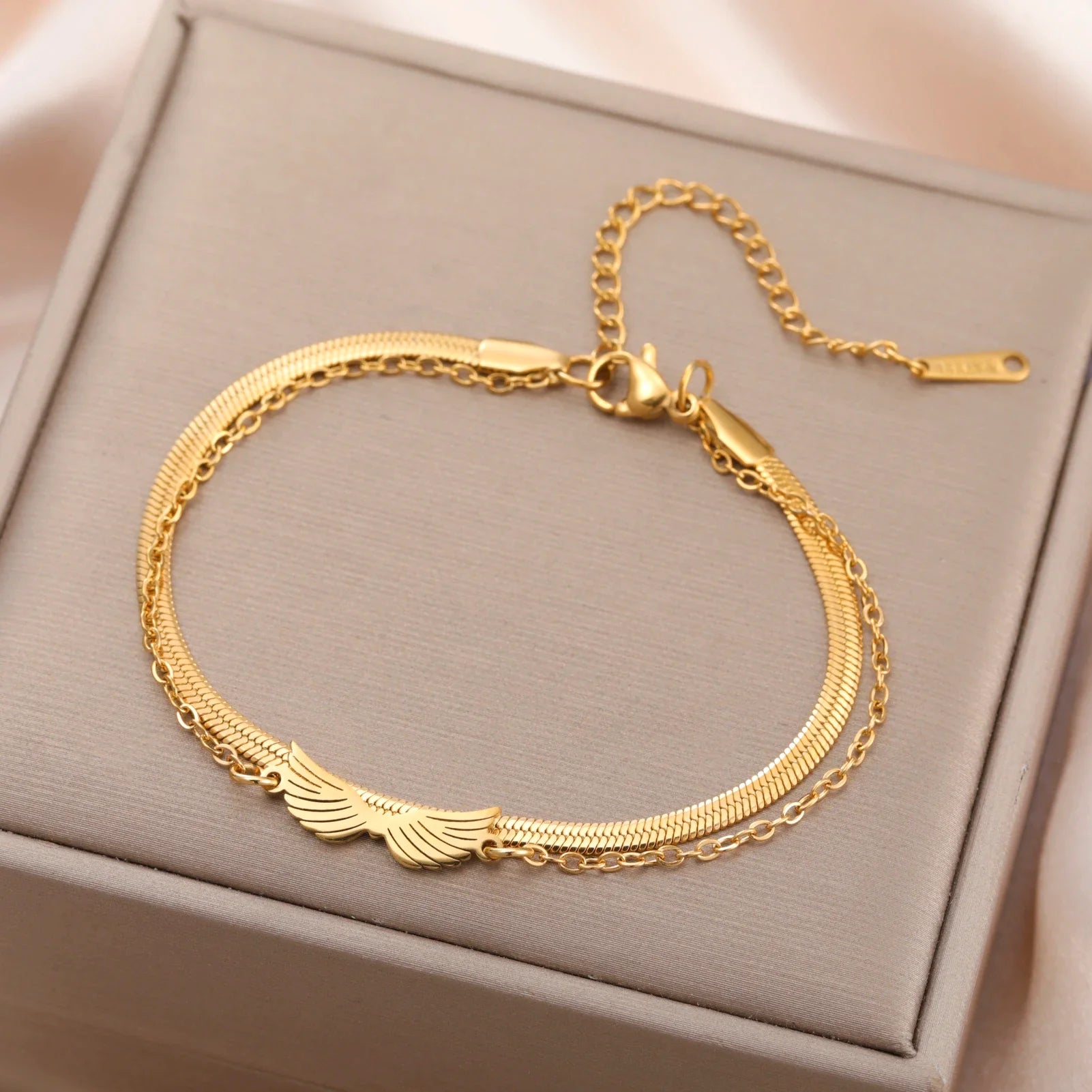 Bracelet aile d'ange femme en acier doré sur fond clair