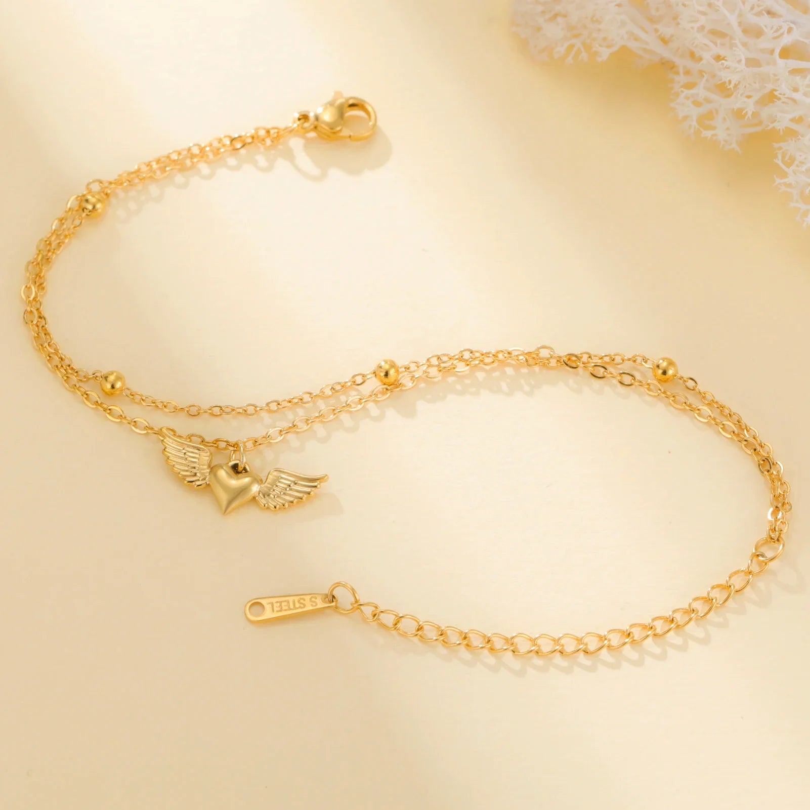 Bracelet cœur ailé femme doré sur fond blanc