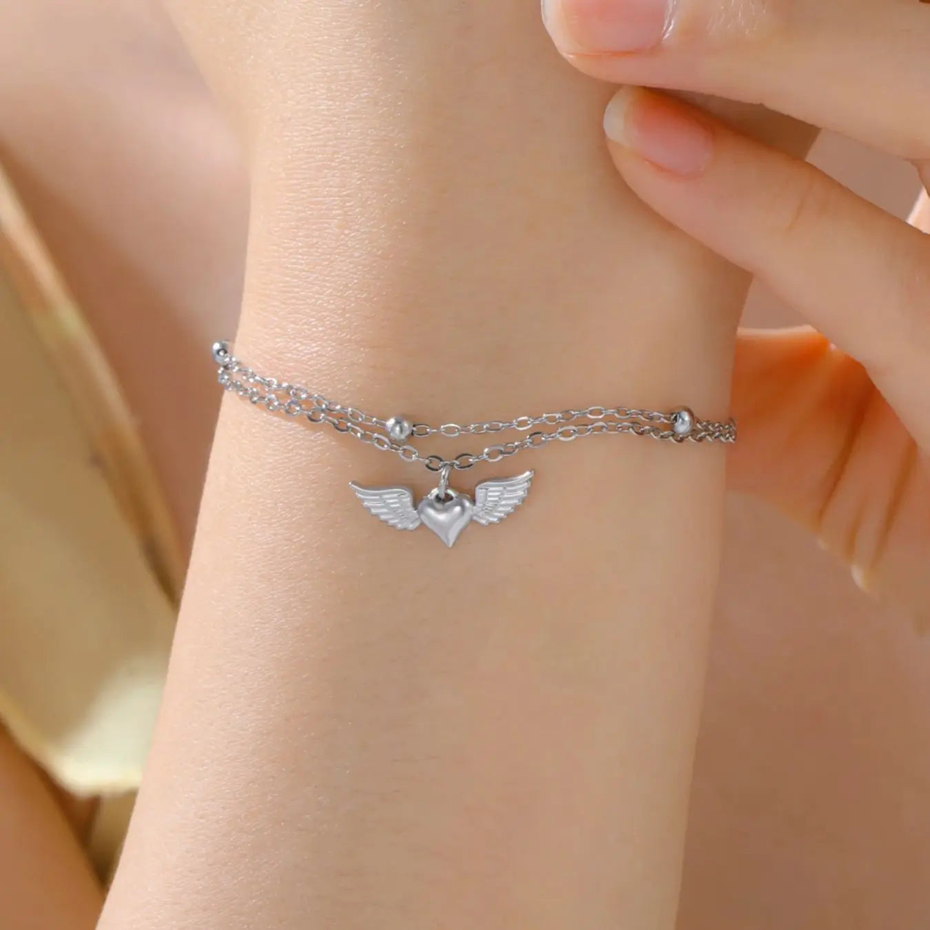 Bracelet cœur ailé femme porté au poignet